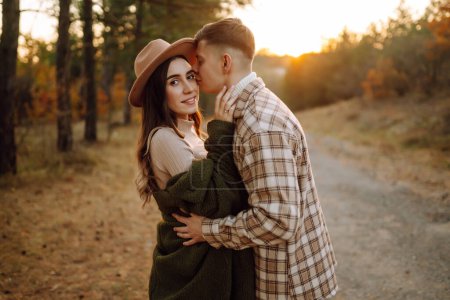 Photo for Happy couple of lovers in casual clothes walk, travel together through the autumn forest at sunset. The concept of people, recreation. Lifestyle. - Royalty Free Image
