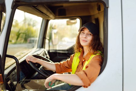 Foto de Conductora mirando por la ventana del camión. Tema Industria del transporte - Imagen libre de derechos