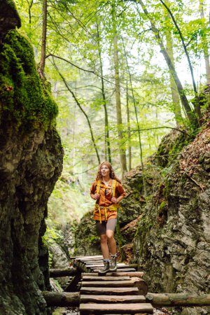 Foto de Aventura, viajes, turismo, senderismo y concepto de personas. Mujer sonriente caminando con mochilas en el bosque. - Imagen libre de derechos