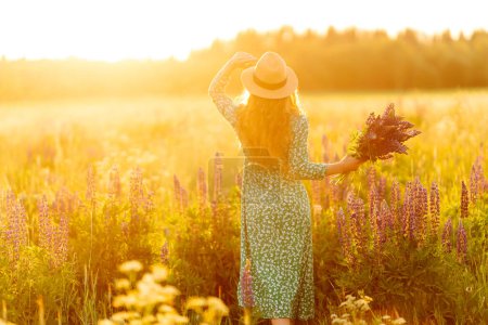 Téléchargez les photos : Jeune femme dans un champ de lavande le jour d'été. Champ de lavande en fleurs. Nature, détente, voyage et mode de vie. - en image libre de droit