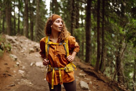 Téléchargez les photos : Randonnée pédestre femme marcher avec un sac à dos de randonnée dans la forêt verte de printemps. Voyage, nature, mode de vie actif - en image libre de droit