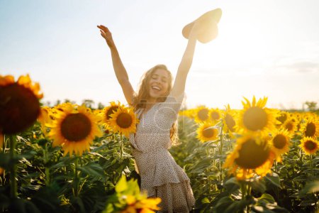 Téléchargez les photos : Belle femme posant dans un champ de tournesols. Mode, nature, voyage et vacances concept. - en image libre de droit