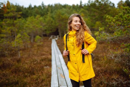 Happy female tourist walk in the autumn forest. Nature. Trips. Active lifestyle.