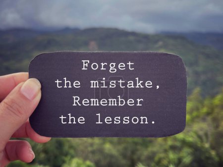 Photo for Motivational and inspirational wording. Forget the mistake, remember the lesson written on a paper. With blurred styled background. - Royalty Free Image