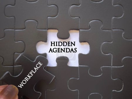 Photo for Workplace issues. HIDDEN AGENDAS and WORKPLACE written on puzzle set. With blurred vintage styled background. - Royalty Free Image