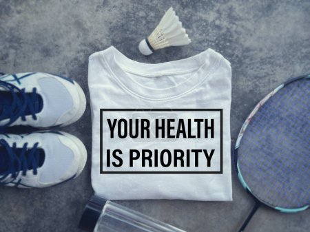Photo for Motivational and inspirational fitness concept.YOUR HEALTH IS PRIORITY written on a shirt. Blurred style background. - Royalty Free Image