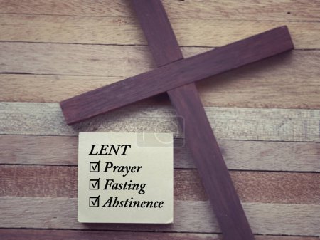 Christianity concept about Ash Wednesday, Good Friday, Lent Season and Holy Week. LENT, PRAYER, FASTING and ABSTINENCE written on a paper. With blurred style background.