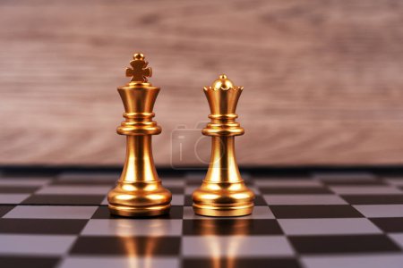 Photo for Motivational business and management concept. Golden chess pieces placed on a chessboard. Blurred styled background. - Royalty Free Image