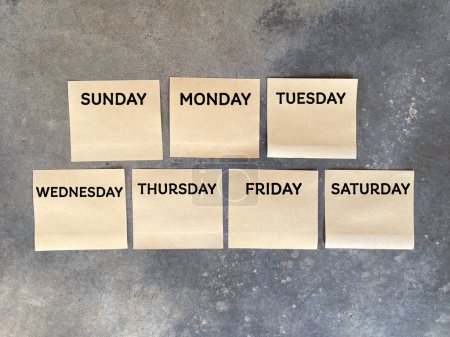 Day, time and calendar concept. SUNDAY, MONDAY, TUESDAY,WEDNESDAY, THURSDAY, FRIDAY and SATURDAY written on adhesive papers. On blurred styled background.