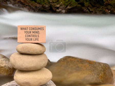 Motivational inspirational quote. What consumes your mind, control your life on paper with nature background