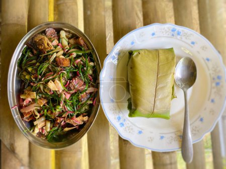 Photo for Mix vegetables and rice wrapped with leaf or linopot on plate. Popular local traditional meal of the kadazan dusun tribe in North Borneo. - Royalty Free Image
