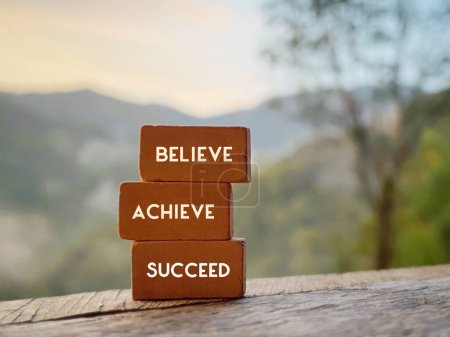 Confidence Inspirational quote. Believe achieve succeed text on stack of bricks.