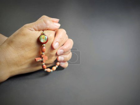 Photo for Christianity Concept - Hands holding Rosary beads in gray background. Stock photo. - Royalty Free Image
