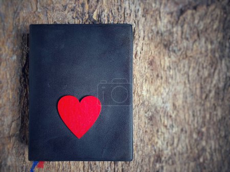 Foto de Una biblia con un corazón rojo en fondo vintage. fe cristiana esperanza amor concepto. - Imagen libre de derechos