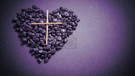 Temporada de Cuaresma, Semana Santa y conceptos de Viernes Santo - imagen de cruz de madera con piedras del corazón en fondo vintage púrpura