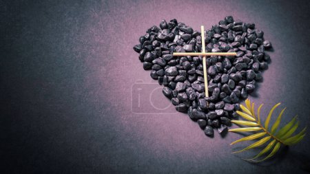 Lent Season,Holy Week and Good Friday concepts - image of wooden cross and palm leave on heart stones in purple vintage background