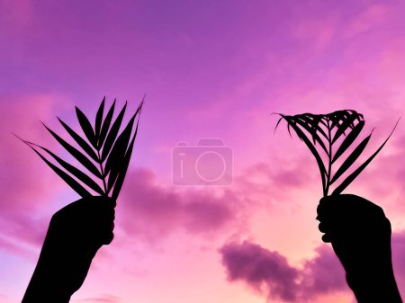 Carême, Semaine Sainte, Dimanche des Rameaux et Vendredi Saint concepts - Carême avec silhouette des mains tenant des feuilles de palmier en fond de ciel violet. Photo de stock.