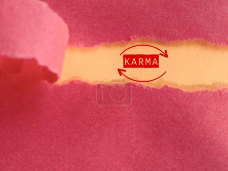 Karma mot derrière fond de papier déchiré. Photo de stock.