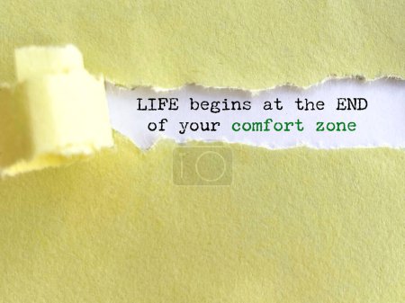 Inspirational motivating quote - life begins at the end of your comfort zone. Text behind torn paper background.