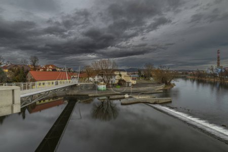 Photo for River Otava and weir with pedestrian bridge near Pisek town in south Bohemia in winter evening - Royalty Free Image