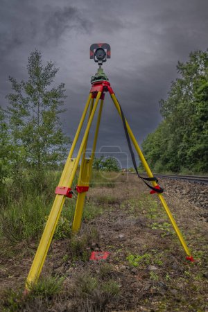 Téléchargez les photos : Arpenteurs avec instruments sur voie ferrée près de la forêt verte fraîche dans le sud de la Bohême - en image libre de droit