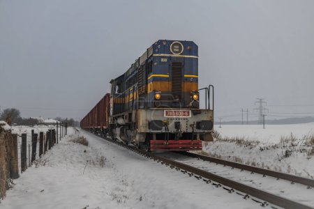 Photo for Cargo train with motor engine in winter snowy morning near cold village Lenesice CZ 12 09 2023 - Royalty Free Image