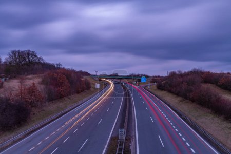 Autopista cerca de las montañas de Krusne con líneas de color nocturno de los coches