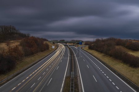 Autopista cerca de las montañas de Krusne con líneas de color nocturno de los coches
