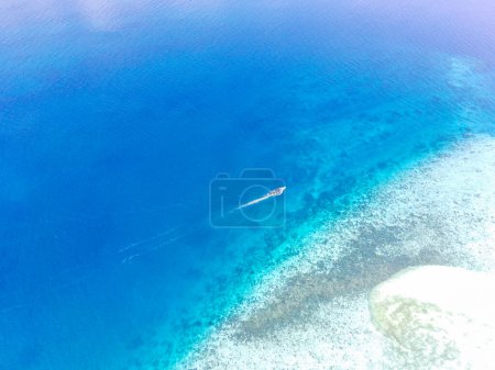 Photo for Boat sails around the Menjangan island of Bali Straits. Indonesia. Aerial Footage taken with drone. - Royalty Free Image