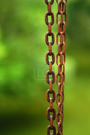 Téléchargez les photos : Gros plan sur des chaînes de métaux lourds rouillées sur fond vert flou. - en image libre de droit