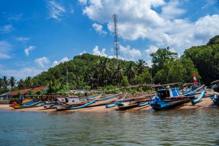 Photo for Local fishermen boats line up by the Kali Cokel or Cokel River, Pacitan. Indonesia. Taken from a moving boat. Travel Photography. - Royalty Free Image