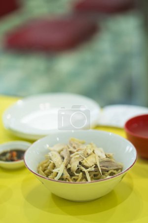 Photo for Mie ayam or chicken noodle served in a bowl on the table. In Surabaya, Indonesia. - Royalty Free Image