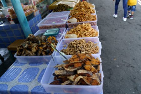 Foto de Camarones crujientes, cangrejos crujientes y pescado frito vendidos en puestos de comida en la playa de Glagah en Kulonprogo, Indonesia. Fotografía callejera. - Imagen libre de derechos