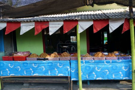 Téléchargez les photos : Crevettes croustillantes, crabes croustillants et poissons frits vendus dans les stands de nourriture à la plage Glagah à Kulonprogo, Indonésie. Photographie de rue. - en image libre de droit