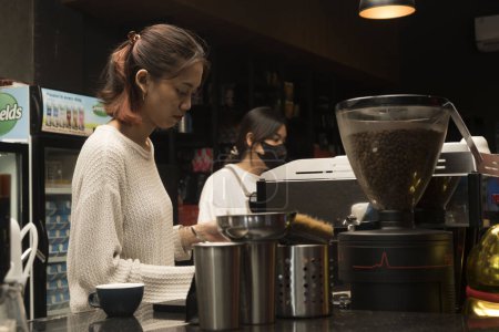 Photo for June 1, 2023. Woman barista preparing coffee for customer at the coffe shop in Yogykarta, Indonesia. People in action photography. - Royalty Free Image