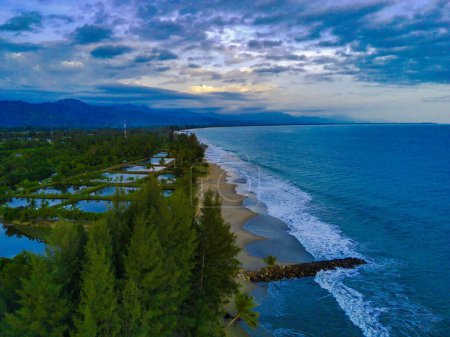 Foto de La hermosa playa de Bali en Blangpidie, Suroeste de Aceh, Indonesia con el océano azul contra el cielo azul disparado con un dron aéreo. Gree pinos en la playa de arena contra el cielo. - Imagen libre de derechos