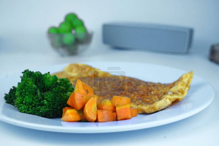 Photo for A healthy breakfast with scrambled eggs, boiled broccoli, and sliced boiled carrots, served on a white plate. Food Photography. - Royalty Free Image