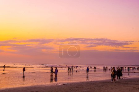 Téléchargez les photos : 31 août 2023. Bali, Indonésie. Les gens qui sont engagés dans des activités apprécient le coucher du soleil avec le bruit des vagues à Kuta Beach, Bali. Editorial stree photo. - en image libre de droit