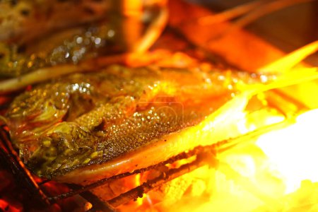 Photo for Traditional Indonesian grilled fish dish marinated in a blend of spices and herbs, then grilled over a big fire. The result is a flavorful and juicy fish that is perfect for a satisfying meal. - Royalty Free Image