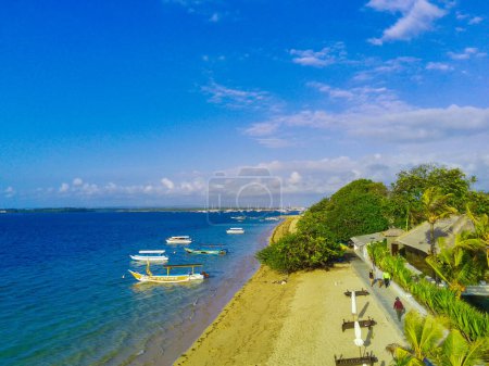 Photo for A serene oasis in the heart of Sanur, Cemara Beach is a picturesque stretch of white sand and crystal clear waters. Swaying palm trees frame the coastline and the moored traditional boats. - Royalty Free Image