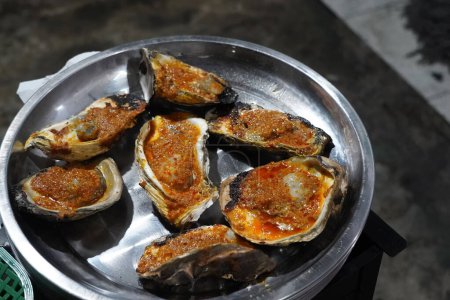 Ostra a la parrilla en Yakarta Food Streets Vendor. Sizzling en una parrilla, ostras regordetas que ofrecen un sabor del mar con cada bocado.