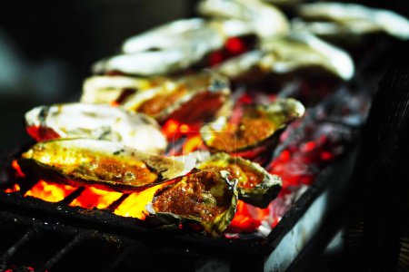 Ostra a la parrilla en Yakarta Food Streets Vendor. Sizzling en una parrilla, ostras regordetas que ofrecen un sabor del mar con cada bocado.