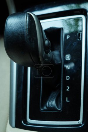 a close up of an automatic car gear shifter. It shows the different gear positions
