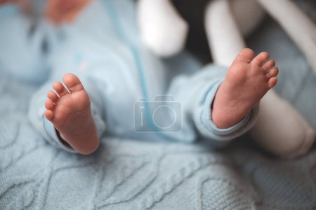 Foto de Primer plano de los pies del bebé recién nacido, sobre un fondo azul suave, primer plano. enfoque selectivo. - Imagen libre de derechos