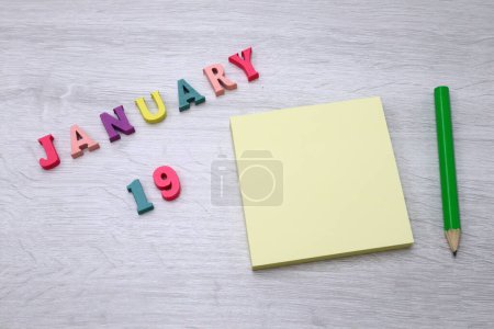 Photo for January  19 - Daily colorful Calendar with Block Notes and Pencil on wood table background, empty space for your text or design - Royalty Free Image