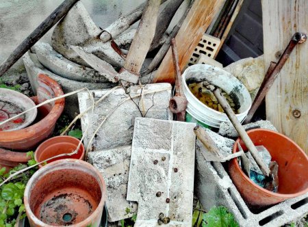Téléchargez les photos : Décharge de déchets de la construction de jardinage, pots cassés, pelle, houe, marteau avec rouille, pierres et tuiles avec escargots. - en image libre de droit