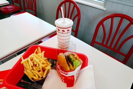 Foto de Los Ángeles, California 23 de junio de 2023: IN-N-OUT Hamburguesa, hamburguesa doble y papas fritas en una bandeja sobre la mesa dentro del restaurante de comida rápida - Imagen libre de derechos