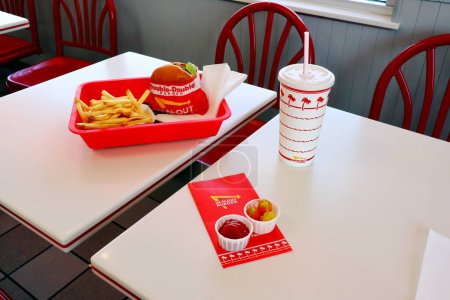 Foto de Los Ángeles, California 23 de junio de 2023: IN-N-OUT Hamburguesa, hamburguesa doble y papas fritas en una bandeja sobre la mesa dentro del restaurante de comida rápida - Imagen libre de derechos