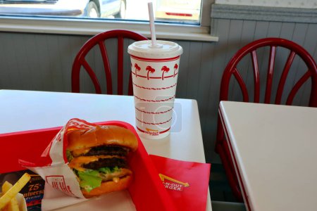 Photo for Los Angeles, California  June 23, 2023: IN-N-OUT Burger, Double-Double Burger and French Fries in a tray on the table inside the fast-food restaurant - Royalty Free Image