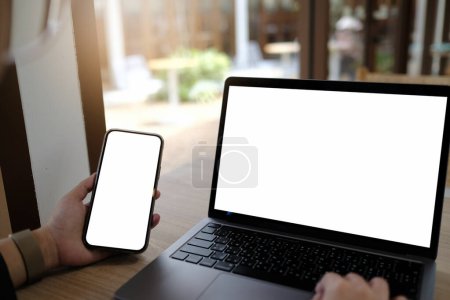 Photo for Mockup image computer,cell phone blank screen for hand typing text,using laptop contact business searching information in workplace on desk at office.design creative work space on wooden desk - Royalty Free Image
